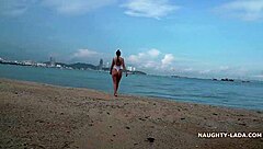 White transparent swimsuit flashes wet body on public beach