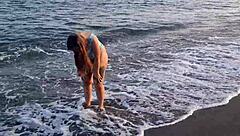 Horny teen shows off her big ass on the public beach, getting her pussy exposed outdoors