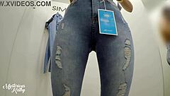 Brazilian beauty with small waist tries on jeans in changing room