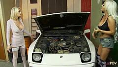 two shaved women in stockings at the car mechanic shop working together