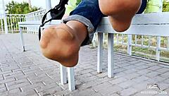 i tease my tan nylon soles in blue jeans on the bench outdoors