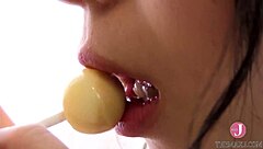 kitchen babe licks candy with naughty look