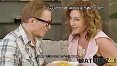 Mature cougar seduces in stockings on sofa.