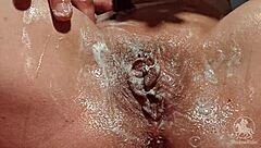 Woman in Bathroom Trims Her Wet Pussy Lips and Clit with Tattoo Visible