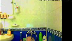 tattooed model in bathroom playing with glass dildo and fingering herself