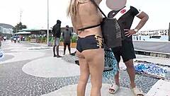 Sexy milf blonde flashes in mini short on Copacabana beach with guys staring