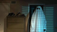 A nude blonde girl celebrates Halloween in bed.