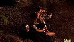 lubing up his cock to slip into the blonde's anal outdoors