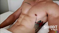 Asian gay hunk participates in a shooting session with other men. He poses confidently.