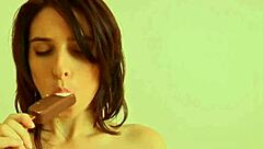 A redhead babe applies cream to her puffy nipples in a close-up view, showcasing her shaved pussy and big natural tits.