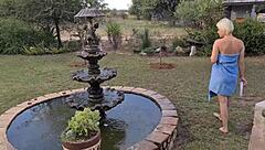 Blonde with bob haircut soaps up her body under outdoor woodland shower.