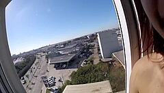 naked at hotel window in front of airport with big tits