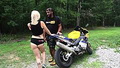 Nadia White drilled on motorcycle outside.