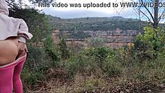 A woman masturbates outdoors near the mountains, reaching orgasm in the fresh air.